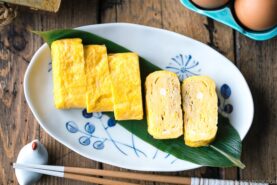 An oval plate containing Japanese sweet rolled omelet.