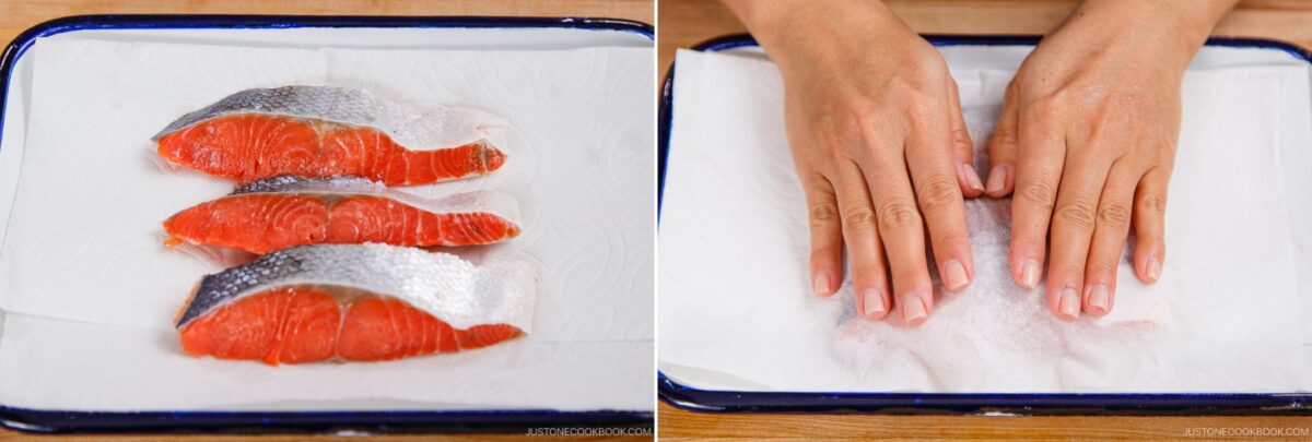 Three raw salmon fillets with skin are placed on a tray lined with paper towels. In the second image, two hands gently press another layer of paper towel on top to pat them dry, preparing the salmon for Kobumaki (Salmon Kombu Roll).