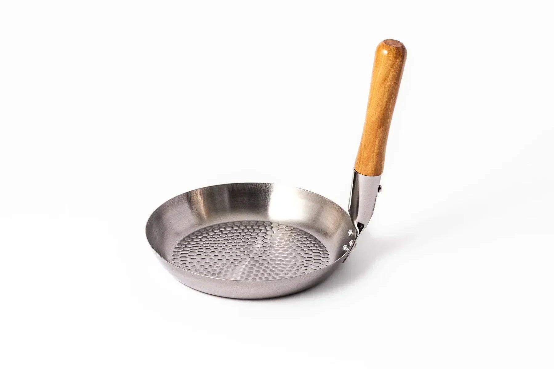 A small, circular stainless steel oyakodon pan with a textured base and an angled wooden handle.
