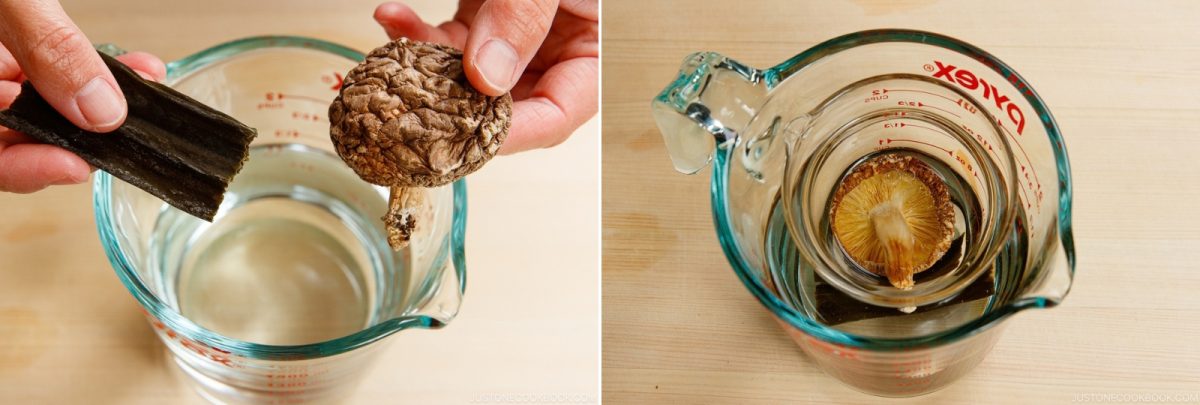 A dried shiitake mushroom and a strip of kombu being placed into a measuring cup filled with water.