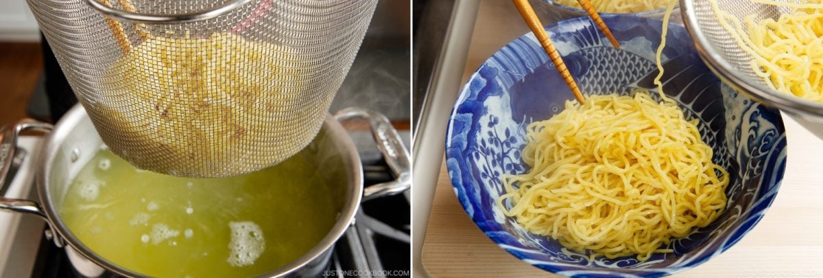 A mesh strainer lifts noodles from a pot of boiling water, and a pair of chopsticks places the cooked noodles into a blue and white patterned bowl.