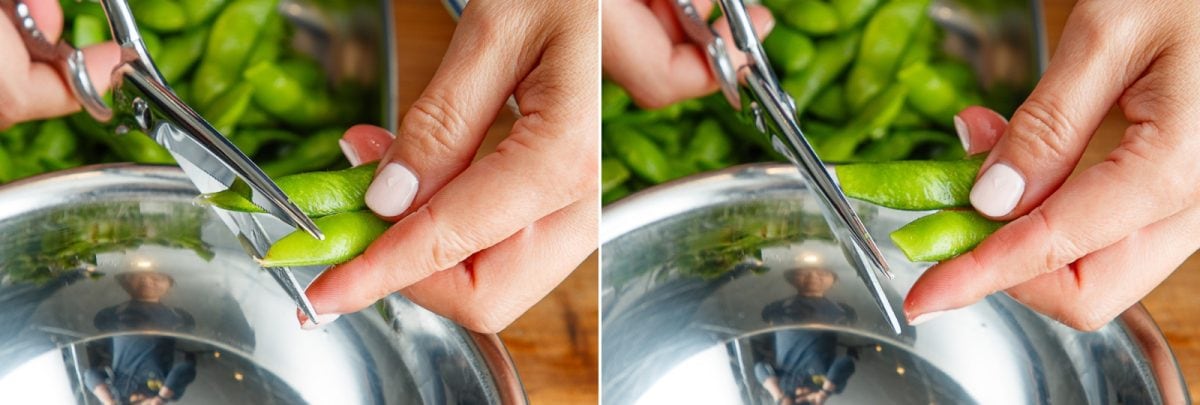 Hands using scissors to trim the ends of fresh green beans over a metal bowl, with green beans and a blurred background visible—perfect preparation for a vibrant Yuzu Kosho Edamame dish.