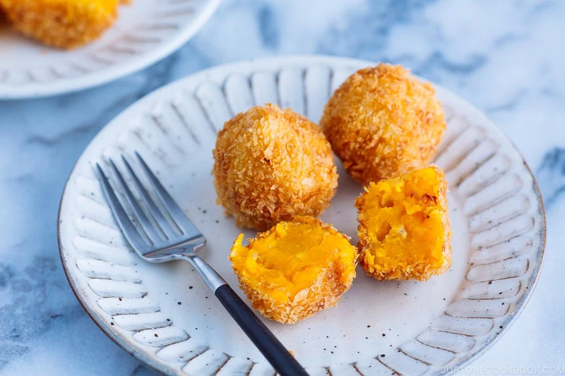 Ceramic plates containing round Kabocha Croquettes (Korokke).