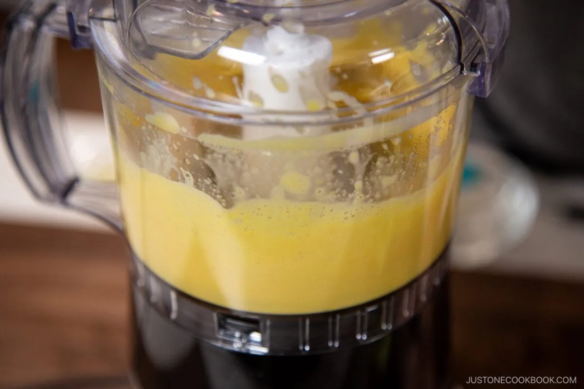 Add egg yolks and the Dijon mustard to the bowl of a small food processor or blender and process for 20 seconds.