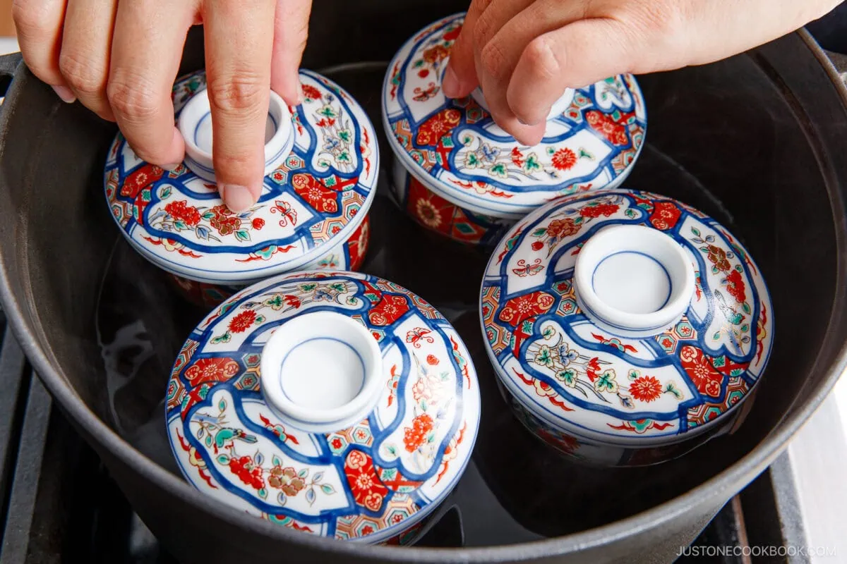 Traditional Japanese chawanmushi served in beautifully decorated ceramic cups with intricate patterns and lids, highlighting authentic Japanese cuisine.